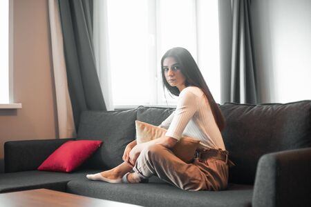 Young woman pretty relaxing on couch in living room. Casual style indoor shootの写真素材