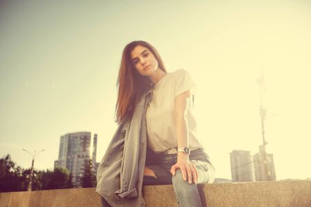 Fashion hipster cool girl relaxing on city street. Pensive female hipster model. Summer sunkight portraitの写真素材