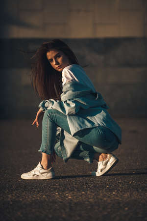 Summer sunny lifestyle fashion portrait. Young stylish hipster woman walking on the street. Summer wear style trendの写真素材