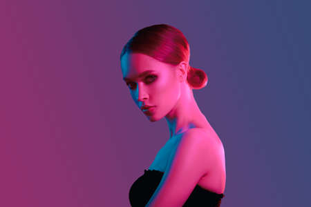 Fashion colorful beauty makeup portrait. Beautiful model girl. Neon lights studio woman closeup...