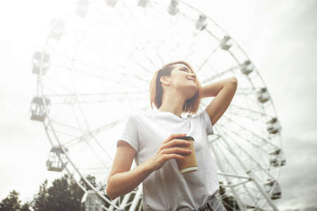 Fashion hipster cool girl relaxing on city street. Pensive female hipster model. Summer sunkight...