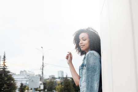 Denim style mulatto girl portrait. Hipster walking in summer cityの写真素材