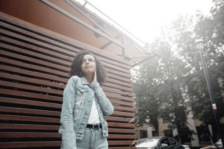 Denim style mulatto girl portrait. Hipster walking in summer cityの写真素材
