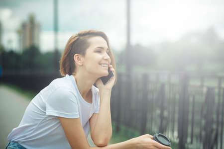 Young woman using mobile phone. Casual hipster girl street portraitの写真素材