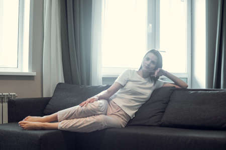 Young woman pretty relaxing on couch in living room. Casual style indoor shootの写真素材