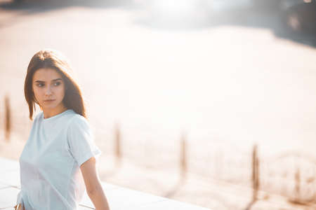 Fashion hipster cool girl relaxing on city street. Pensive female hipster model. Summer sunlight portraitの写真素材