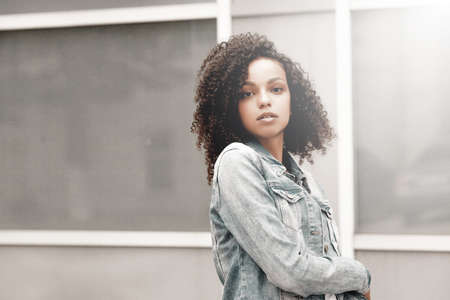 Attractive dark skin girl portrait. City hipster young woman walking on streetの写真素材