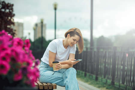 Young woman using mobile phone. Casual hipster girl street portraitの写真素材