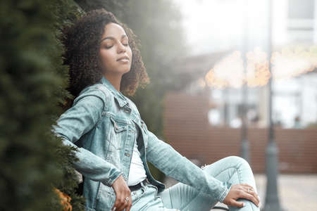 Denim style mulatto girl portrait. Hipster walking in summer cityの写真素材