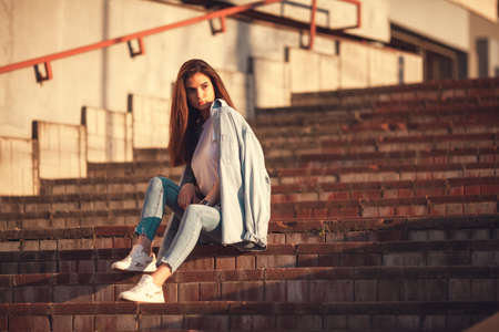Summer sunny lifestyle fashion portrait. Young stylish hipster woman walking on the street. Summer wear style trendの写真素材