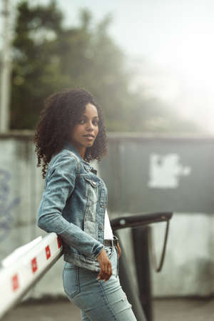 Attractive dark skin girl portrait. City hipster young woman walking on streetの写真素材
