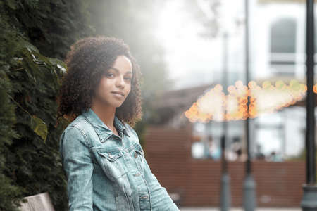 Denim style mulatto girl portrait. Hipster walking in summer cityの写真素材