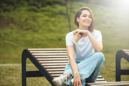 Fashion hipster cool girl relaxing on city street. Pensive female hipster model. Summer sunkight portraitの写真素材