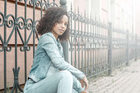 Attractive dark skin girl portrait. City hipster young woman walking on streetの写真素材