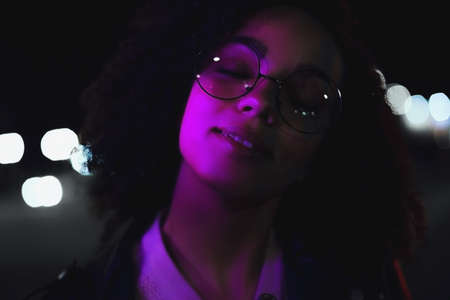 Night portrait of beautiful fashion young african american girl. Cute curly model