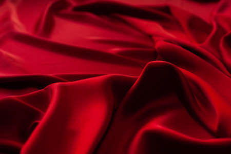 Red fabric texture background. Silk satin folds. Smooth elegant wallpaperの写真素材