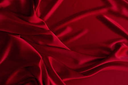 Red fabric texture background. Silk satin folds. Smooth elegant wallpaperの写真素材