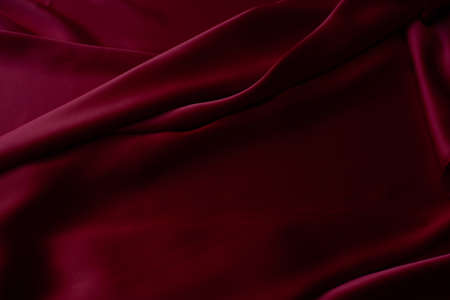 Red smooth cloth folds texture background. Luxury satin fabric.の写真素材