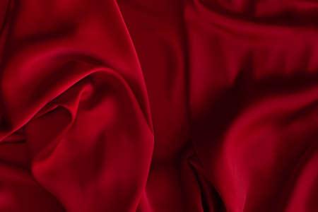Red fabric texture background. Silk satin folds. Smooth elegant wallpaperの写真素材