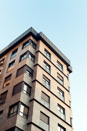 High rise building with a blue sky background. Apartment residential house and home facade...