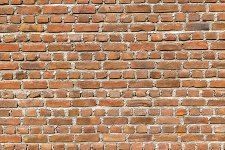 Red brick wall. Background of old vintage wall texture. Weathered stained old brick wallの写真素材