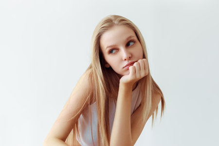 Funny student girl portrait on white background. Grimacing emotion model. Studio portraitの写真素材