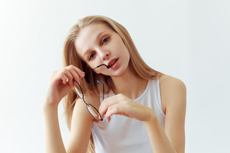 Funny student girl portrait on white background. Grimacing emotion model. Studio portraitの写真素材