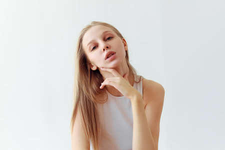 Funny student girl portrait on white background. Grimacing emotion model. Studio portraitの写真素材
