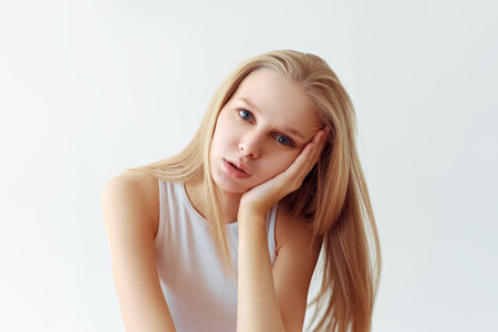 Funny student girl portrait on white background. Grimacing emotion model. Studio portraitの写真素材