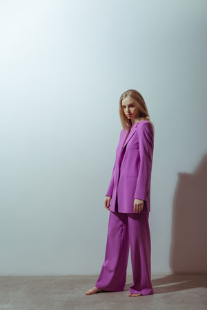 Fashionable model wearing pink color suit. Studio photo shoot. Classic styleの写真素材