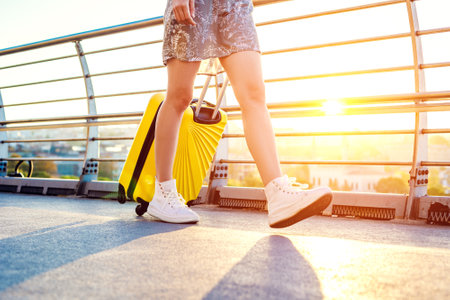 Woman walks around the city carrying a yellow suitcase. Tourist travelingの写真素材