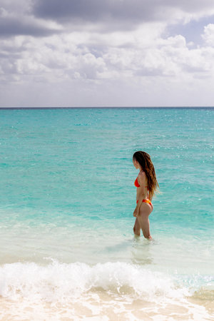 Young beautiful dreadlocks Asian model standing on beach in bikini. Beach travel. Summer vibes vacation on the beach. Perfect seascapeの写真素材