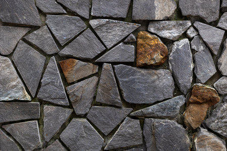 Textured slate stone wall with irregular pattern and natural rock colors.