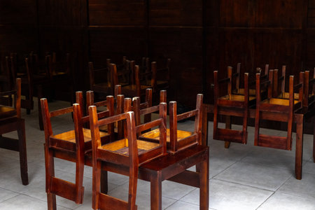 Empty restaurant interior with stacked wooden chairs on tables.