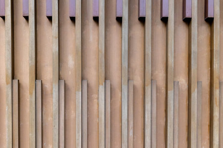 Geometric vertical wooden patterns on modern architectural wall.