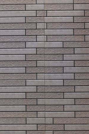 Gray textured brick wall with linear pattern.