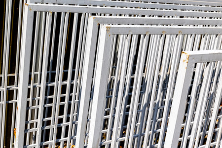 Stacked metal fences with rusty accents in sunlight.