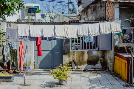 Sunlit courtyard with laundry hanging on clothesline in urban setting.