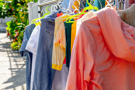 Colorful clothing hanging on outdoor clothesline in sunny urban setting.の写真素材