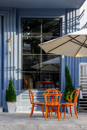 Charming outdoor cafe seating with wooden chairs and table.の写真素材
