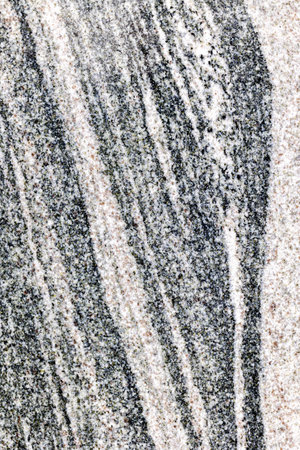 Textured natural granite surface with wavy patterns and neutral tones.の写真素材