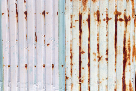 Weathered metal texture with rusty vertical lines and corroded surface patterns.の写真素材