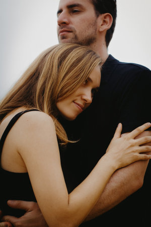 Young caucasian couple embracing outdoors in a tender moment.の写真素材
