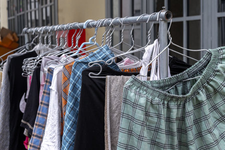 Colorful assortment of clothing hanging on a metal rack.の写真素材