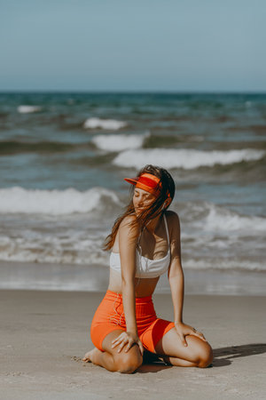 Young caucasian female enjoying a sunny day on the beach in sporty attire.の写真素材
