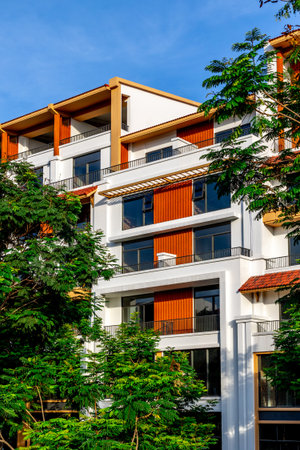 Modern residential building with trees and blue sky background.の写真素材