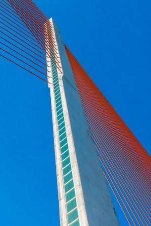 Abstract perspective of cable-stayed bridge against blue sky.