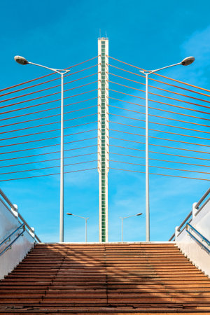 Modern suspension bridge against clear blue sky with symmetrical design.の写真素材