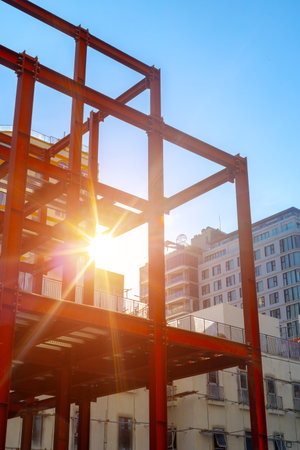 Sunlight shining through steel building frame construction urban architecture.