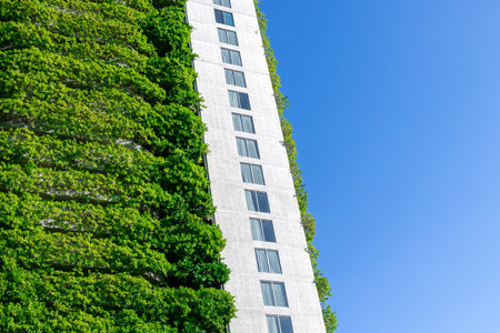 Vertical garden on modern urban building against clear blue sky.の写真素材